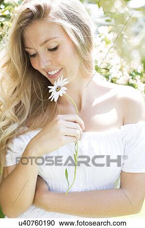 Stock Image - Woman holding daisy. Fotosearch
