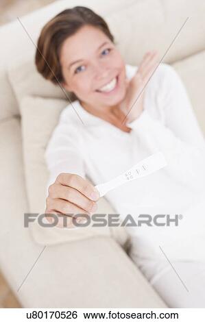 Woman holding positive pregnancy test View Large Photo Image Stock Photograph - Woman holding positive pregnancy test. Fotosearch