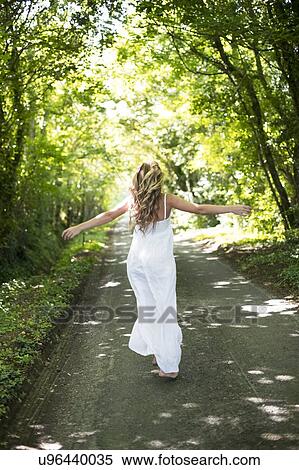 Woman in long white dress on country lane View Large Photo Image Stock Photography - Woman in long white dress on country lane. Fotosearch