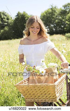 Woman in meadow with bicycle View Large Photo Image Stock Image - Woman in meadow with bicycle. Fotosearch