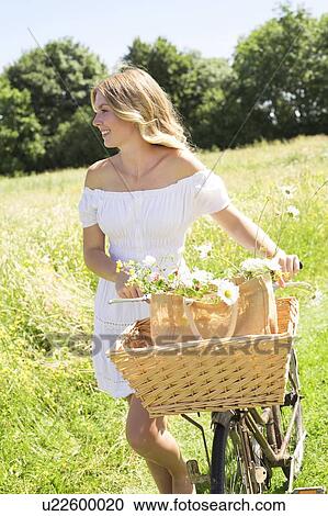 Woman in meadow with bicycle View Large Photo Image Stock Image - Woman in meadow with bicycle. Fotosearch
