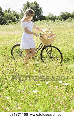 Woman in meadow with bicycle View Large Photo Image Stock Photography - Woman in meadow with bicycle. Fotosearch