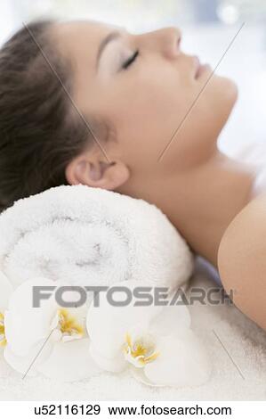 Woman lying on towel in spa View Large Photo Image Stock Photo - Woman lying on towel in spa. Fotosearch