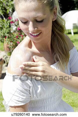 Woman rubbing sun cream on shoulder View Large Photo Image Stock Image - Woman rubbing sun cream on shoulder. Fotosearch