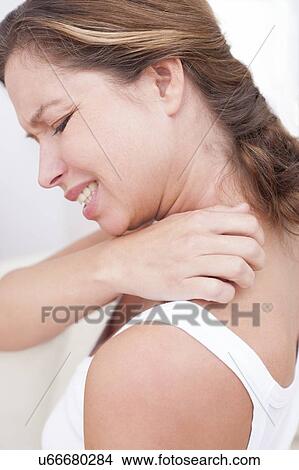 Picture - Woman scratching shoulder. Fotosearch
