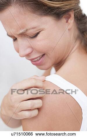 Stock Photograph - Woman scratching shoulder. Fotosearch