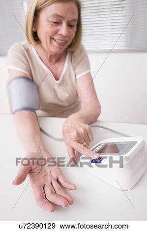 Woman taking her own blood pressure View Large Photo Image Stock Photo - Woman taking her own blood pressure. Fotosearch