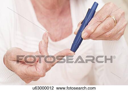 Stock Image - Woman testing glucose. Fotosearch