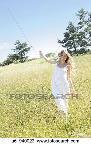 Woman walking in meadow View Large Photo Image Stock Image - Woman walking in meadow. Fotosearch