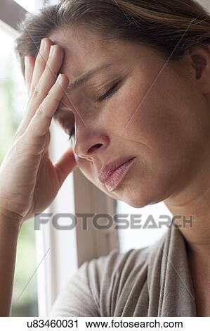 Stock Image - Woman with hand on forehead. Fotosearch