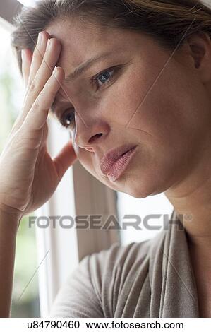 Stock Image - Woman with hand on forehead. Fotosearch