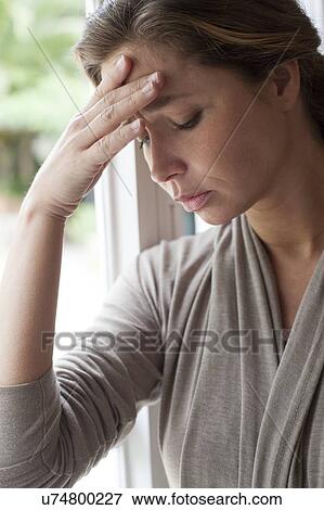 Stock Photo - Woman with hand on forehead. Fotosearch