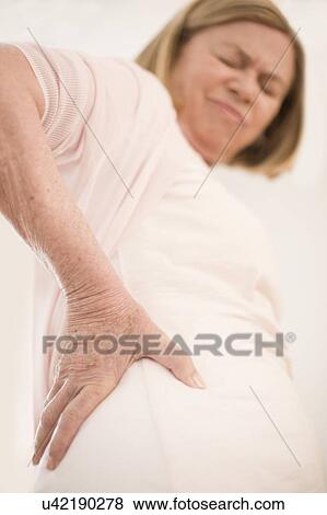 Stock Photo - Woman with hip pain. Fotosearch