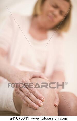 Stock Image - Woman with knee pain. Fotosearch