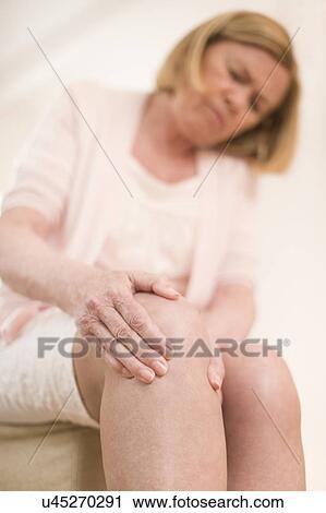 Stock Image - Woman with knee pain. Fotosearch