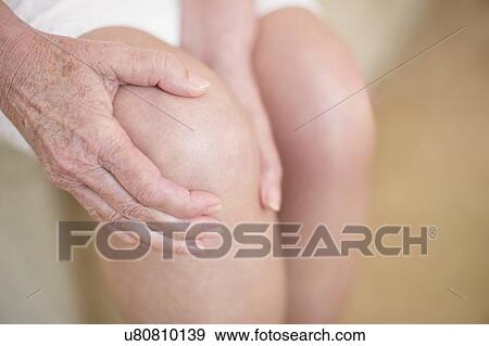 Stock Photo - Woman with knee pain. Fotosearch