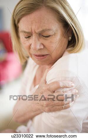 Stock Image - Woman with shoulder pain. Fotosearch