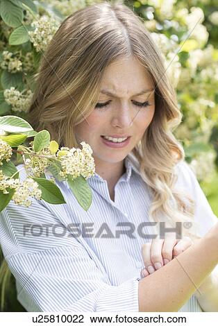 Stock Image - Young woman scratching arm. Fotosearch
