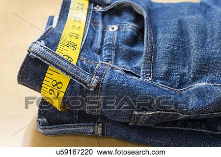 Stock Image - A pair of jeans and tape measure. Fotosearch