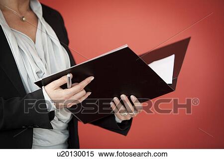 Stock Photography - Businesswoman holding black folder. Fotosearch