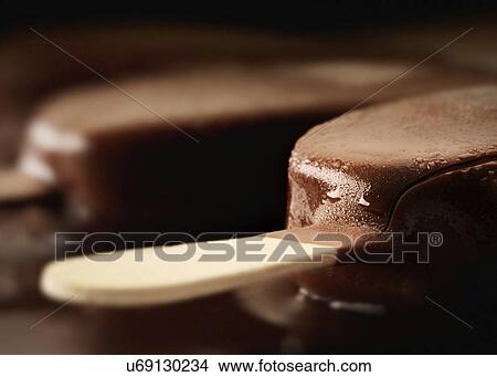 Picture - Chocolate ice cream and stick, close up. Fotosearch
