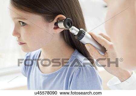 Female doctor examining girl's ear View Large Photo Image Stock Image - Female doctor examining girl's ear. Fotosearch