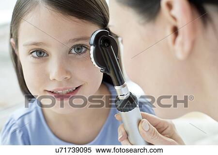 Female doctor examining girl's eye View Large Photo Image Stock Photography - Female doctor examining girl's eye. Fotosearch