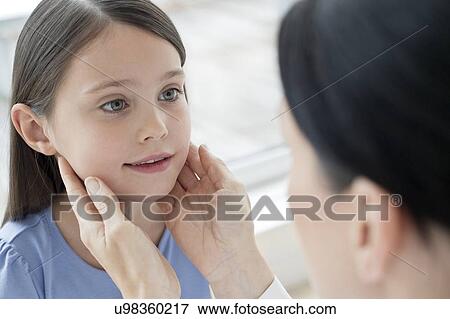 Stock Photo - Female doctor examining girl's glands. Fotosearch