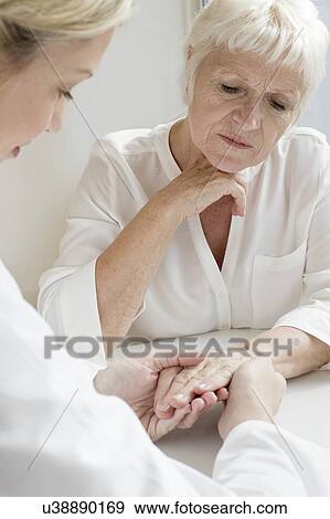 Female doctor examining senior patient's hand View Large Photo Image Stock Photo - Female doctor examining senior patient's hand. Fotosearch