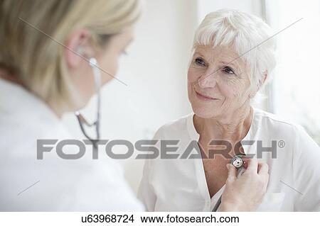 Picture - Female doctor examining senior woman. Fotosearch
