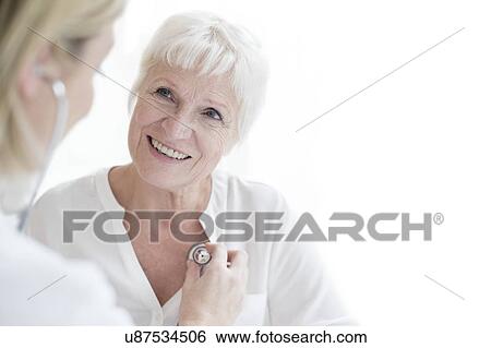 Female doctor examining senior woman View Large Photo Image Stock Photograph - Female doctor examining senior woman. Fotosearch