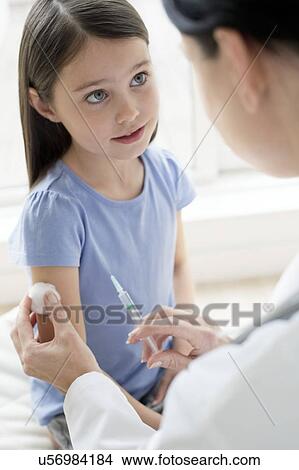 Picture - Female doctor giving girl injection. Fotosearch