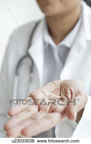 Female doctor holding an IUD View Large Photo Image Stock Photo - Female doctor holding an IUD. Fotosearch