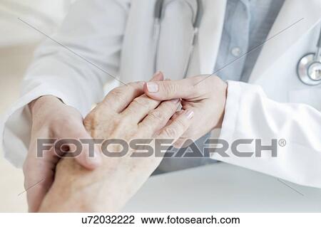 Female doctor holding senior patient's hand View Large Photo Image Stock Image - Female doctor holding senior patient's hand. Fotosearch