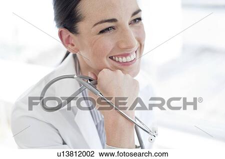 Stock Image - Female doctor holding stethoscope. Fotosearch