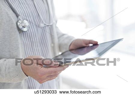 Female doctor holding tablet View Large Photo Image Stock Image - Female doctor holding tablet. Fotosearch