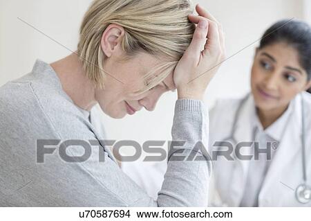 Picture - Female doctor listening to patient. Fotosearch