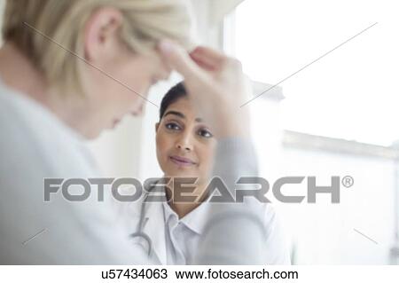 Stock Image - Female doctor listening to patient. Fotosearch