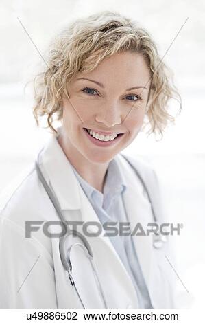 Female doctor smiling towards camera View Large Photo Image Stock Image - Female doctor smiling towards camera. Fotosearch