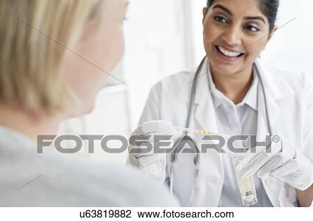 Female doctor testing patient's urine View Large Photo Image Stock Image - Female doctor testing patient's urine. Fotosearch