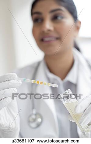 Stock Photo - Female doctor testing urine. Fotosearch