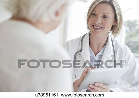 Female doctor using digital tablet with patient View Large Photo Image Stock Image - Female doctor using digital tablet with patient. Fotosearch