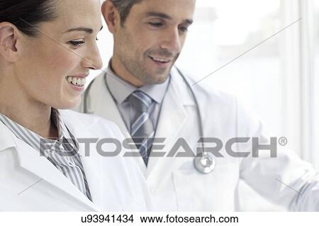 Male and female doctors using tablet View Large Photo Image Picture - Male and female doctors using tablet. Fotosearch