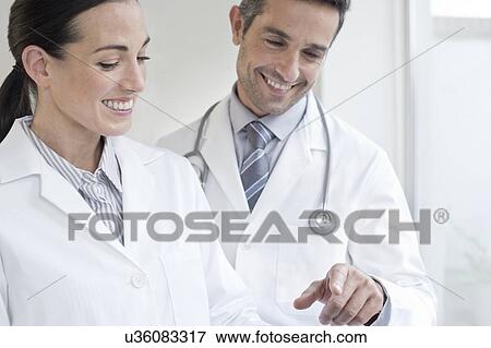Stock Photo - Male and female doctors using tablet. Fotosearch