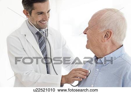 Stock Image - Male doctor examining patient. Fotosearch