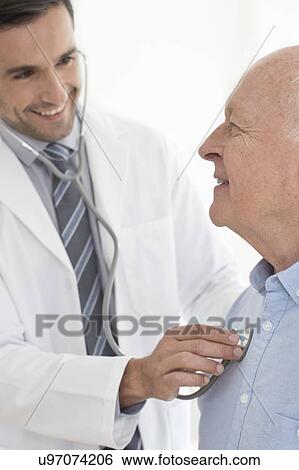 Stock Photograph - Male doctor examining patient. Fotosearch