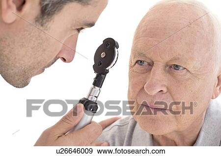 Male doctor examining senior patient's eye View Large Photo Image Stock Photo - Male doctor examining senior patient's eye. Fotosearch