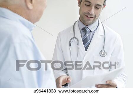 Male doctor holding medical notes View Large Photo Image Stock Photo - Male doctor holding medical notes. Fotosearch