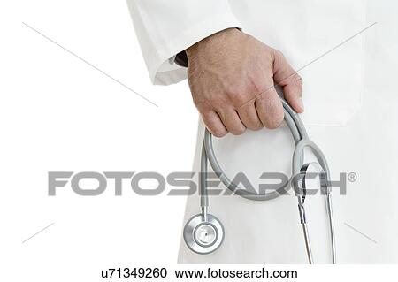 Stock Image - Male doctor holding stethoscope. Fotosearch
