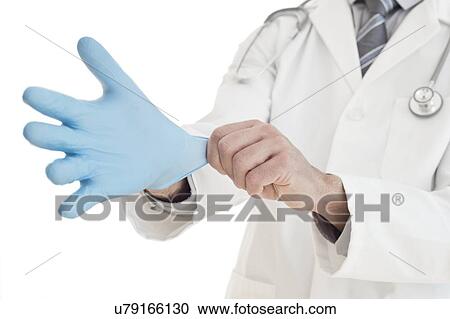 Stock Image - Male doctor putting on blue latex glove. Fotosearch